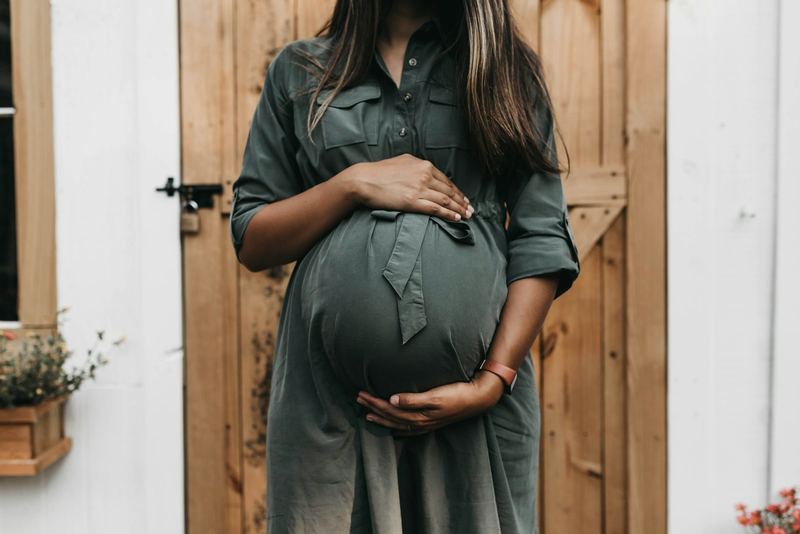 Schwangere Frau im grünen Kleid